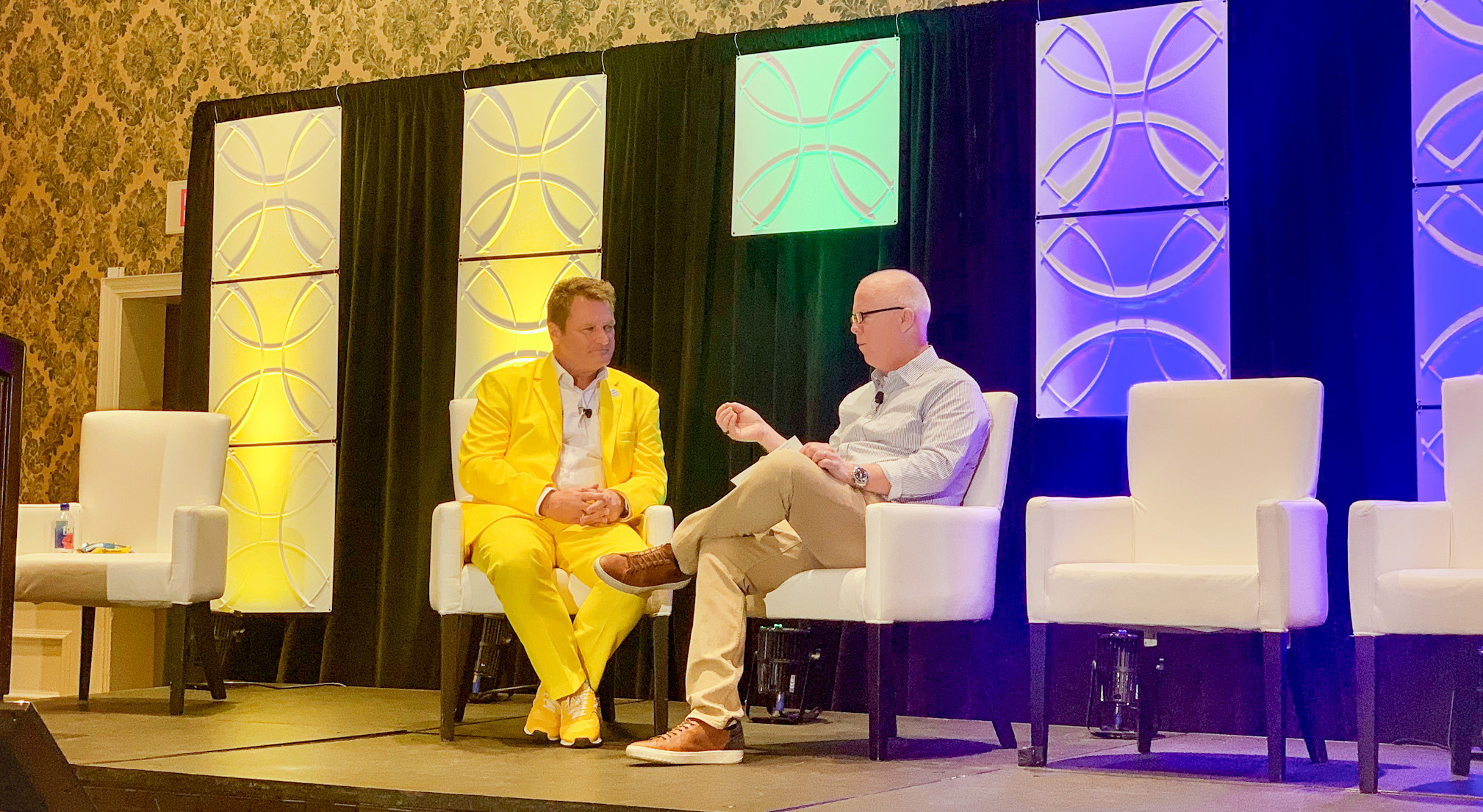 Boris Stockermann and Will Townsend on stage. Boris wears a yellow suit. Interview at LoRaWAN Live Orlando